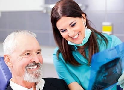 Older man in dental chair smiling