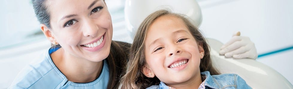 Smiling dental team member and young patient