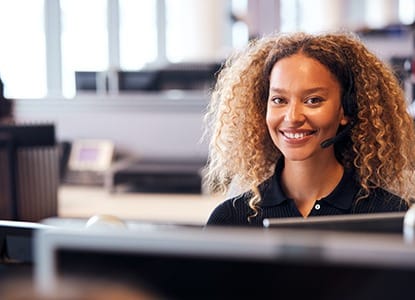 person sitting at their desk and smiling