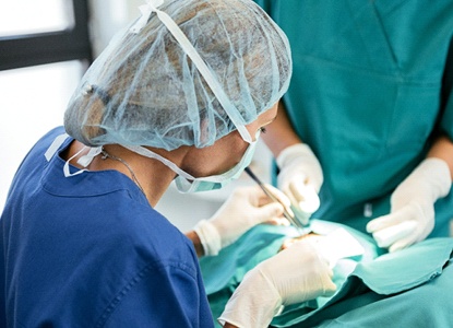 A dentist and team members performing dental implant surgery on a patient