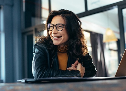 smiling person sitting in front of their laptop