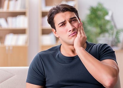 Man in pain holding jaw