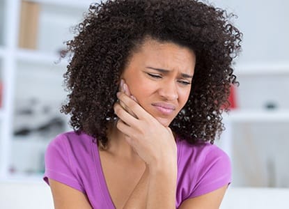 Woman in pain holding jaw