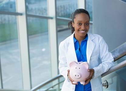 smiling dentist holding a pink piggy bank