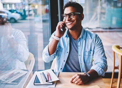 person smiling and speaking on the phone