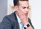 Man holding jaw in pain