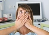 Woman in dental chair covering mouth