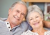 Smiling older man and woman on couch